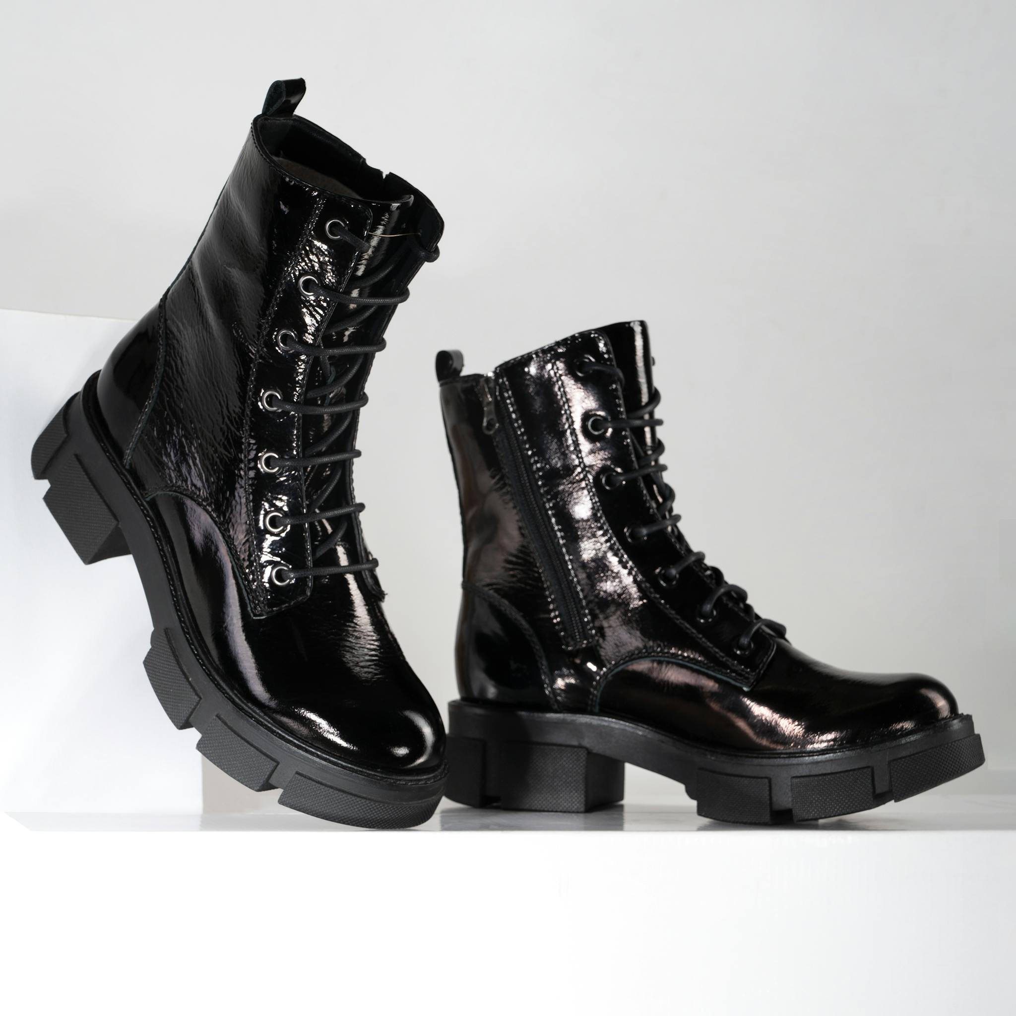 Glossy black patent leather boots showcasing elegant and trendy fashion footwear.